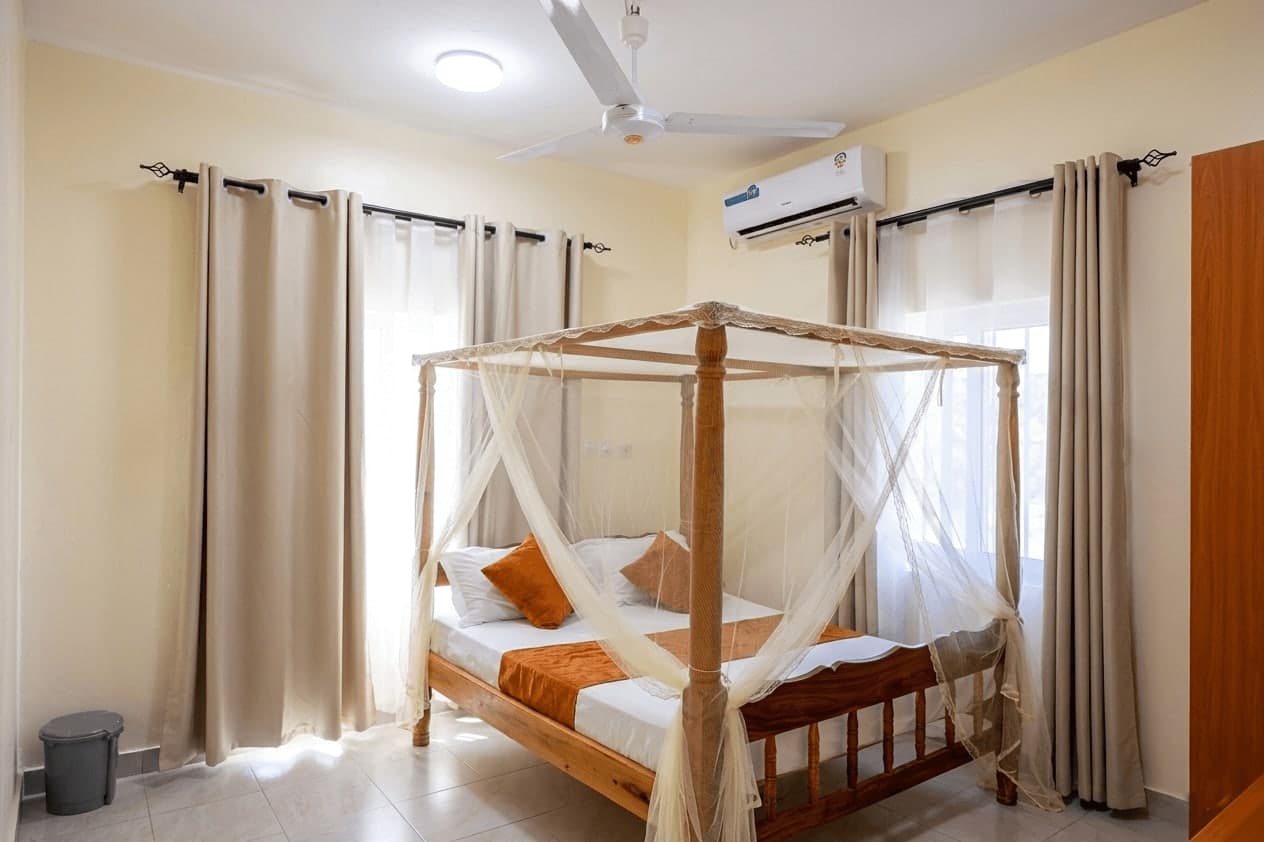 Bedroom with a four-poster bed, mosquito net and air conditioning