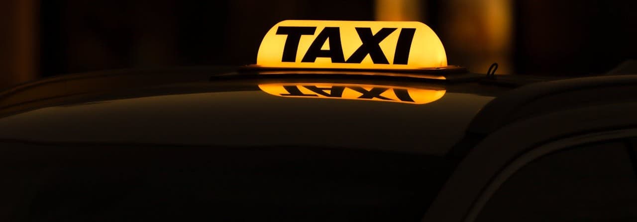 An illuminated taxi sign at night